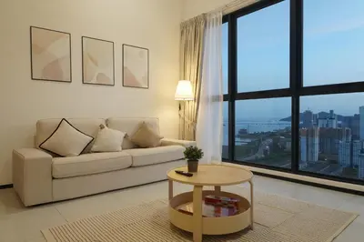 a living room with a couch and a large window at Urban Suites Seaview 3Bedrooms 2Carparks 8pax in Jelutong