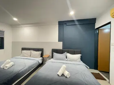 two beds sitting next to each other in a room at Cozy Roomstay Teluk Intan in Teluk Intan