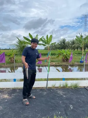 a man standing next to a tree with at IDAMAN COTTAGE Sekinchan in Tanjung Karang