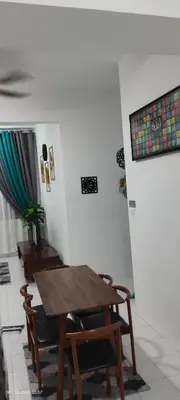 a dining room with a wooden table and chairs at Nana Homestay in Parit Buntar