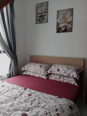 a bedroom with a bed with red and white sheets at Nana Homestay in Parit Buntar