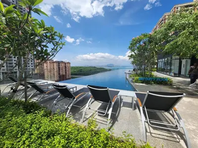 a group of chairs sitting next to a river at Urban Suites - Queens Suite in Jelutong