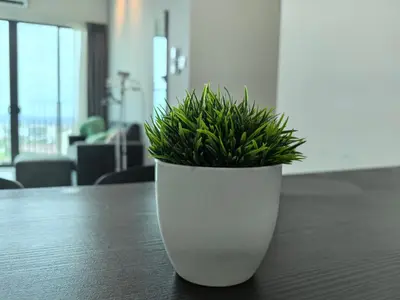 a white planter with a plant on a table at Platinum Suite Meritus by Moowin in Perai