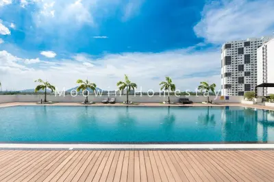 a large swimming pool with palm trees and a building at Platinum Suite Meritus by Moowin in Perai