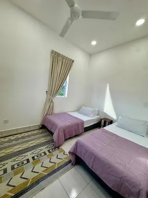 a bedroom with two beds and a window at Rimbayu 81 in Kampung Bota Kiri