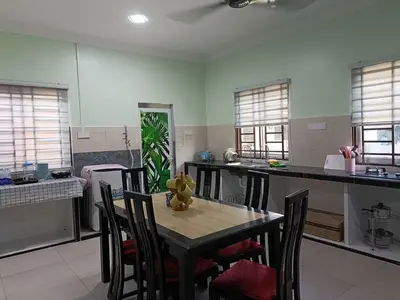 a kitchen with a table and chairs in a room at NHR Harmoni in Simpang Ampat