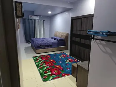 a room with a bedroom with a bed and a rug at Homestay Lyn Impian in Tanjung Rambutan