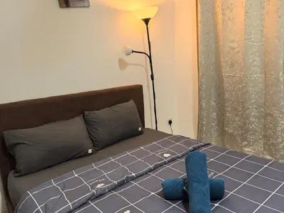 a bed with a blue stuffed animal laying on it at Royal Comfort Suite Meritus near swimming pool in Perai