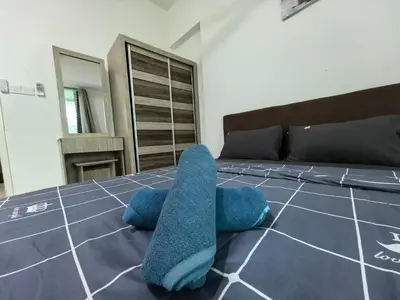 a bedroom with a bed with blue towels on it at Royal Comfort Suite Meritus near swimming pool in Perai