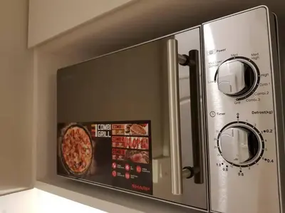 a microwave oven with a pizza inside of it at Heritage Loft on Beach Street near UNESCO Zone & Street Art 1 in George Town