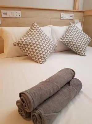 a rolled up towel on a bed with pillows at Heritage Loft on Beach Street near UNESCO Zone & Street Art 2 in George Town