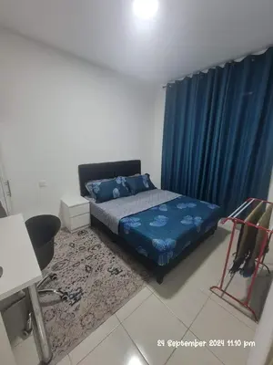 a bedroom with a bed and a blue curtain at Kamilia Homestay Anderson Ipoh in Kampong Simee