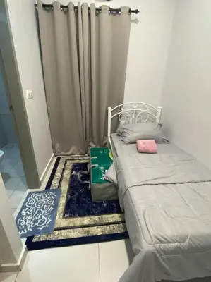 a small bedroom with a bed and a curtain at Mini Studio in Batu Kawan in Batu Kawan