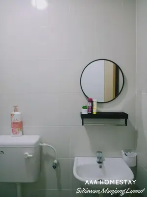 a bathroom with a mirror and a sink at AAA homestay in Sitiawan