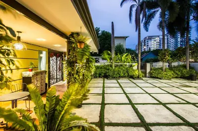 a patio with palm trees and a building at Surprised Homestay by uBook in Butterworth