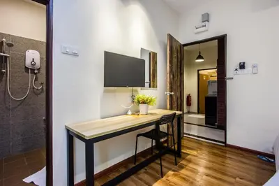 a bathroom with a desk with a television on the wall at Surprised Homestay by uBook in Butterworth