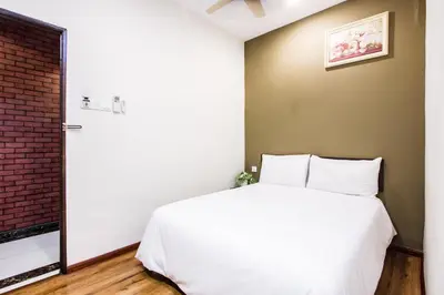 a bedroom with a white bed and a brick wall at Surprised Homestay by uBook in Butterworth