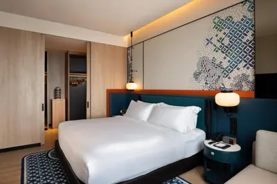 a bedroom with a large white bed and a couch at Iconic Marjorie Hotel, Penang, a Tribute Portfolio Hotel in Bayan Lepas