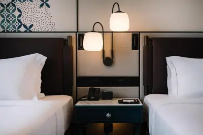 a hotel room with two beds and a phone on a table at Iconic Marjorie Hotel, Penang, a Tribute Portfolio Hotel in Bayan Lepas