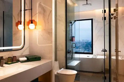 a bathroom with a shower and a toilet and a sink at Iconic Marjorie Hotel, Penang, a Tribute Portfolio Hotel in Bayan Lepas