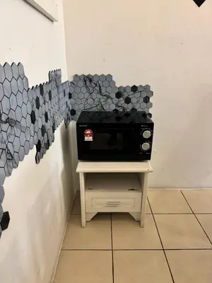 a microwave sitting on a table in a room at AYAAN SERENE BUDGET HOMESTAY with FREE WiFi and Netflix in Tanah Rata
