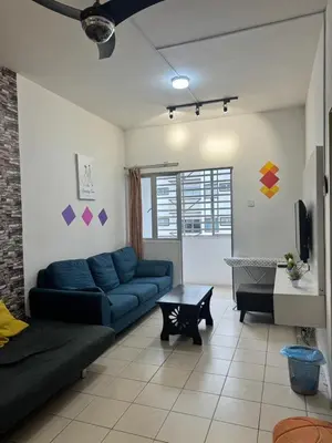 a living room with a blue couch and a table at AYAAN SERENE BUDGET HOMESTAY with FREE WiFi and Netflix in Tanah Rata