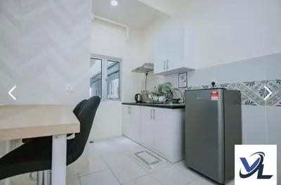 a white kitchen with a table and a refrigerator at anderson condo in Ipoh