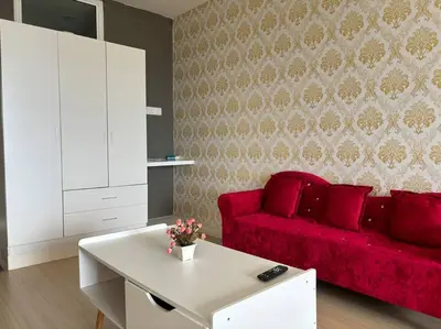 a living room with a red couch and a table at KF Homestay Deluxe Suite in Kampar