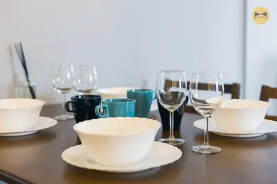 a table topped with white bowls and glasses of wine at Seaview Sunrise 1BR at Tropicana 218 at Central Location & Food Hunt Friendly in George Town