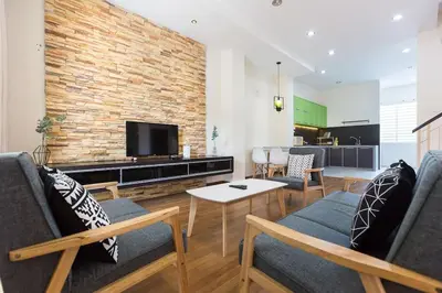 a living room with two couches and a tv at Landed 3BR Home Near Beach, Seafood & Fisherman Village in Bayan Lepas