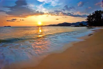 a sunset on a beach with the ocean at Landed 3BR Home Near Beach, Seafood & Fisherman Village in Bayan Lepas