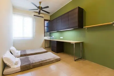 a room with two beds and a desk in it at Landed 3BR Home Near Beach, Seafood & Fisherman Village in Bayan Lepas