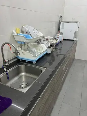 a kitchen counter with a dish drying rack next to a sink at Homestay Cactus Apparment in Brinchang