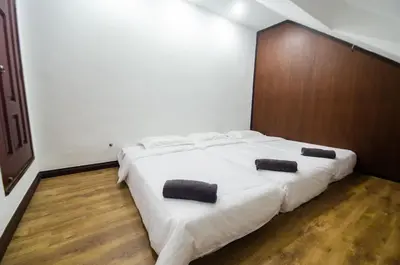 a bedroom with a large white bed with two pillows on it at Bukit Mertajam Double Storey Bungalow 15pax BBQ KTV in Bukit Mertajam