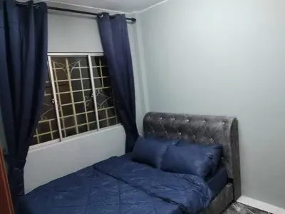 a bed with blue pillows in a room with a window at Amara Homestay Cameron Highlands in Cameron Highlands