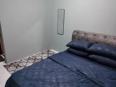 a bedroom with a blue comforter and pillows on a bed at Amara Homestay Cameron Highlands in Cameron Highlands