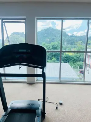 a room with a treadmill in front of a large window at Anderson Ipoh by Iconique Espace in Ipoh