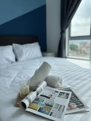 a magazine and a thermometer and a candle on a bed at Anderson Ipoh by Iconique Espace in Ipoh