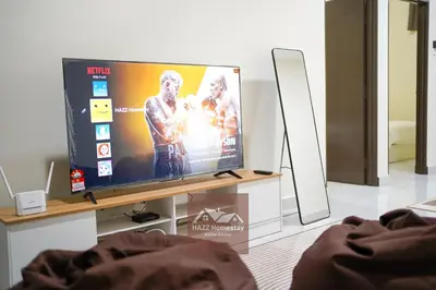 a flat screen tv on a stand in a living room at HAZZ Homestay Kulim IV in Kulim