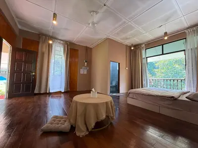 a bedroom with a bed and a table in a room at Villa Kuala Woh Resort in Tapah