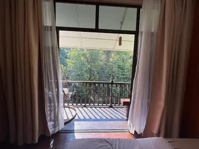 a bedroom with a window with a view of a balcony at Villa Kuala Woh Resort in Tapah