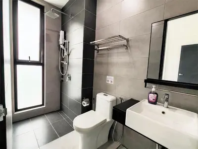 a bathroom with a white toilet and a sink at SoftGrey 2 Rooms Apartment, 4 plus 2 Pax at Urban Suites in Jelutong