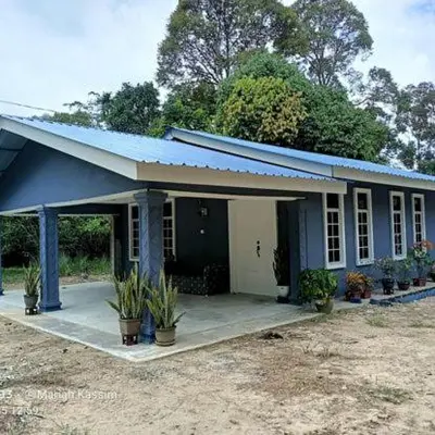 a small blue house with potted plants in front of it at MKF Homestay Padang Stang, Gerik in Gerik