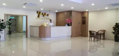 a woman standing at a counter in a lobby at Lipis Plaza Hotel in Kuala Lipis