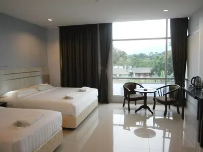 a hotel room with two beds and a table and chairs at Hotel Kawan in Tapah