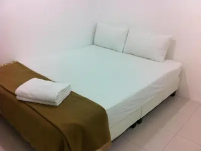 a white bed with two pillows on top of it at Chin Yee Hotel in Teluk Intan