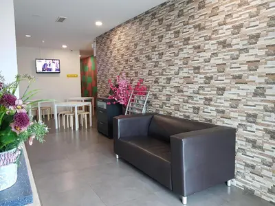a lobby with a leather couch and a brick wall at Hotel Bestari Prima in Kuala Lipis
