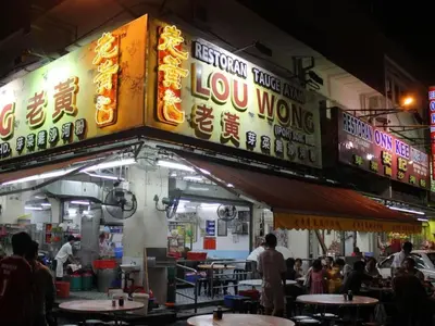 a restaurant with signs on the side of a building at Le Metrotel in Ipoh