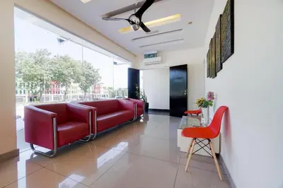 a living room with a red couch and a table at GM Holiday Hotel Permai Jaya in Kampong Tebing Rabak