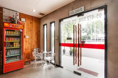 a restaurant with a table and chairs and a window at OYO 89454 Hotel Pavilion Inn in Ayer Tawar